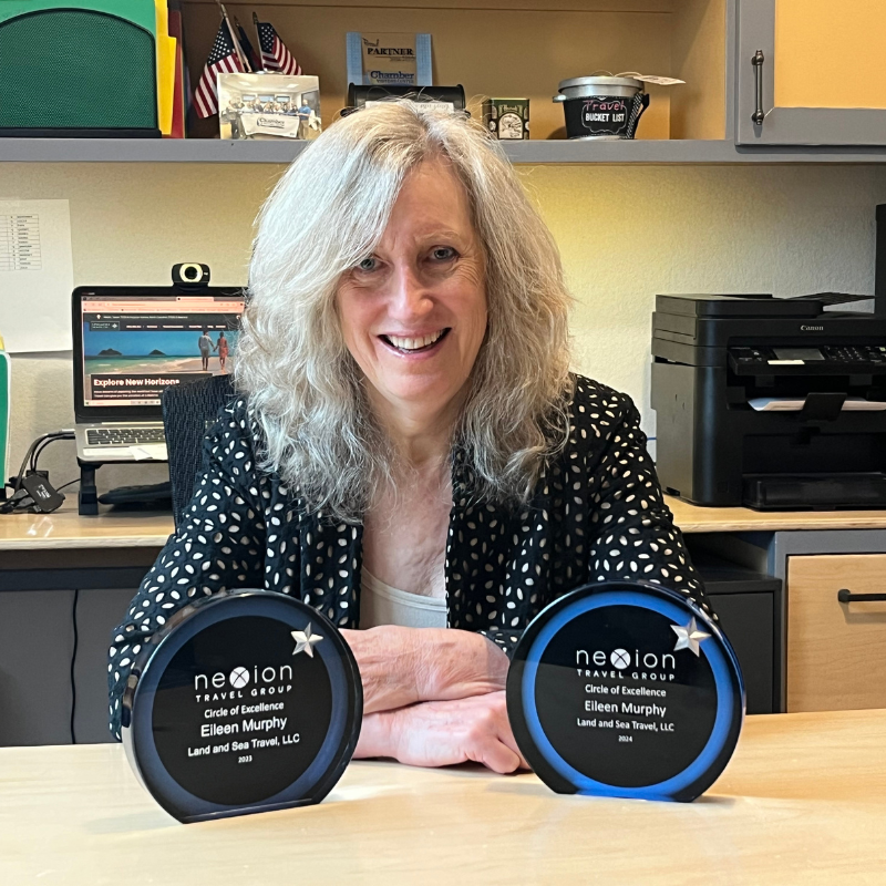 Eileen Murphy sitting at a desk at Land and Sea Travel