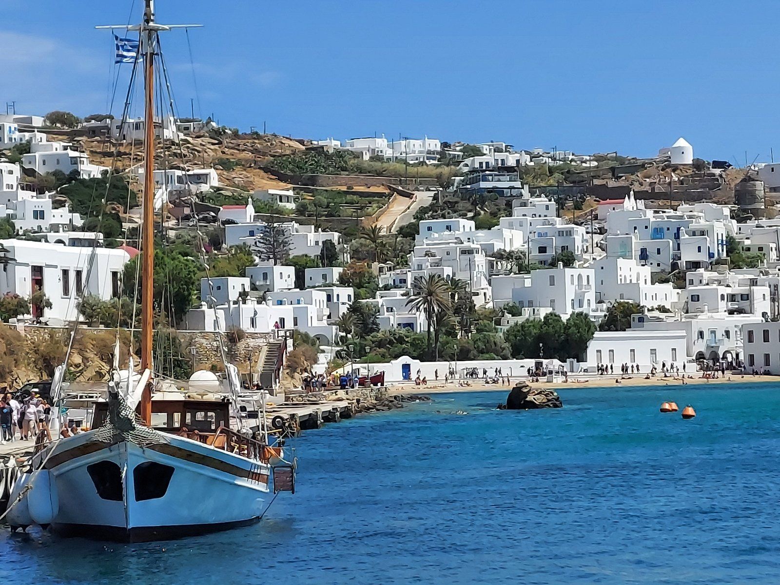 It's all Greek to Me Mykonos Greece hillside of homes water and boat