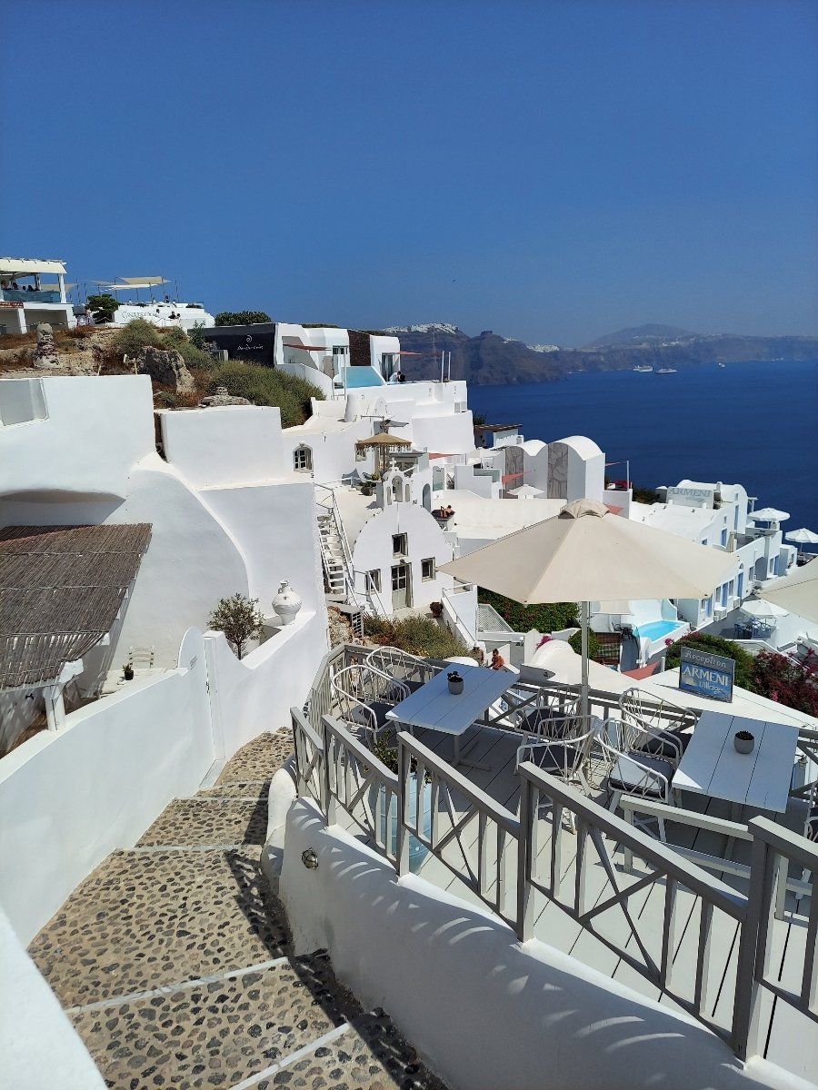 It's all Greet to Me Santorini hillside of homes and ocean