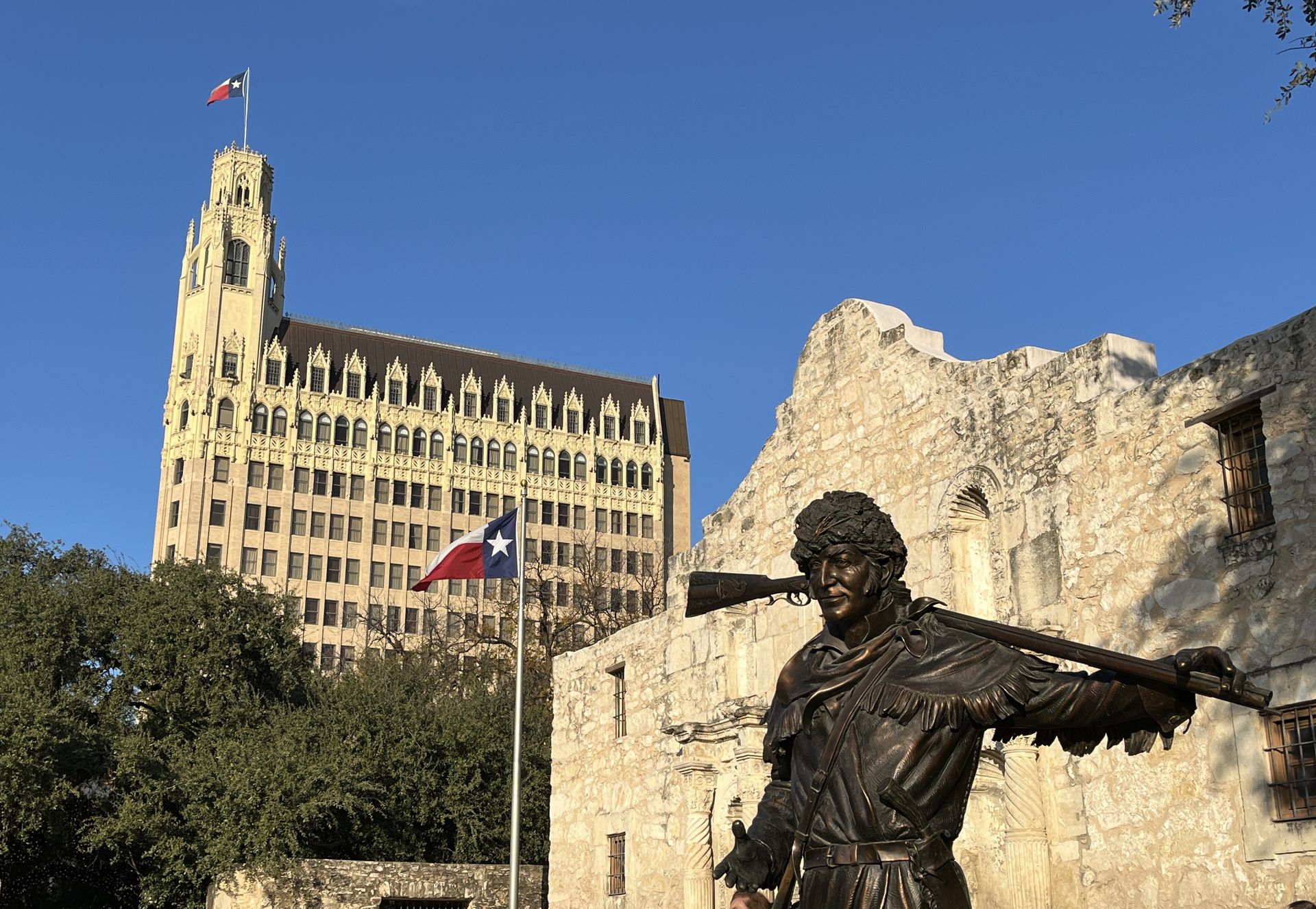 The-Alamo Mission San-Antonio Texas Bronze Davie Crocket in front of facade with Emily D West Morgan Hotel