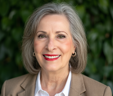 A woman in a suit and white shirt is smiling for the camera.