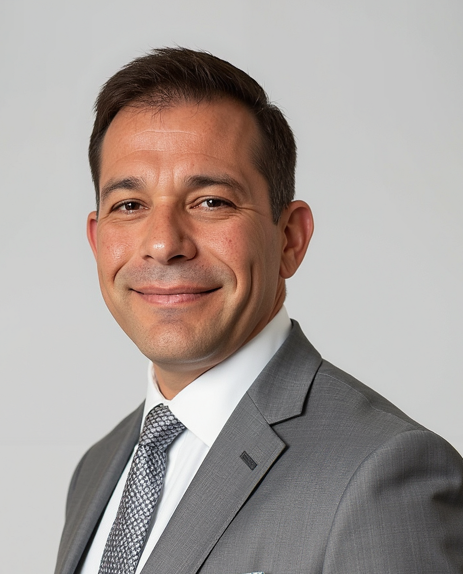 A man in a suit and tie is smiling for the camera.