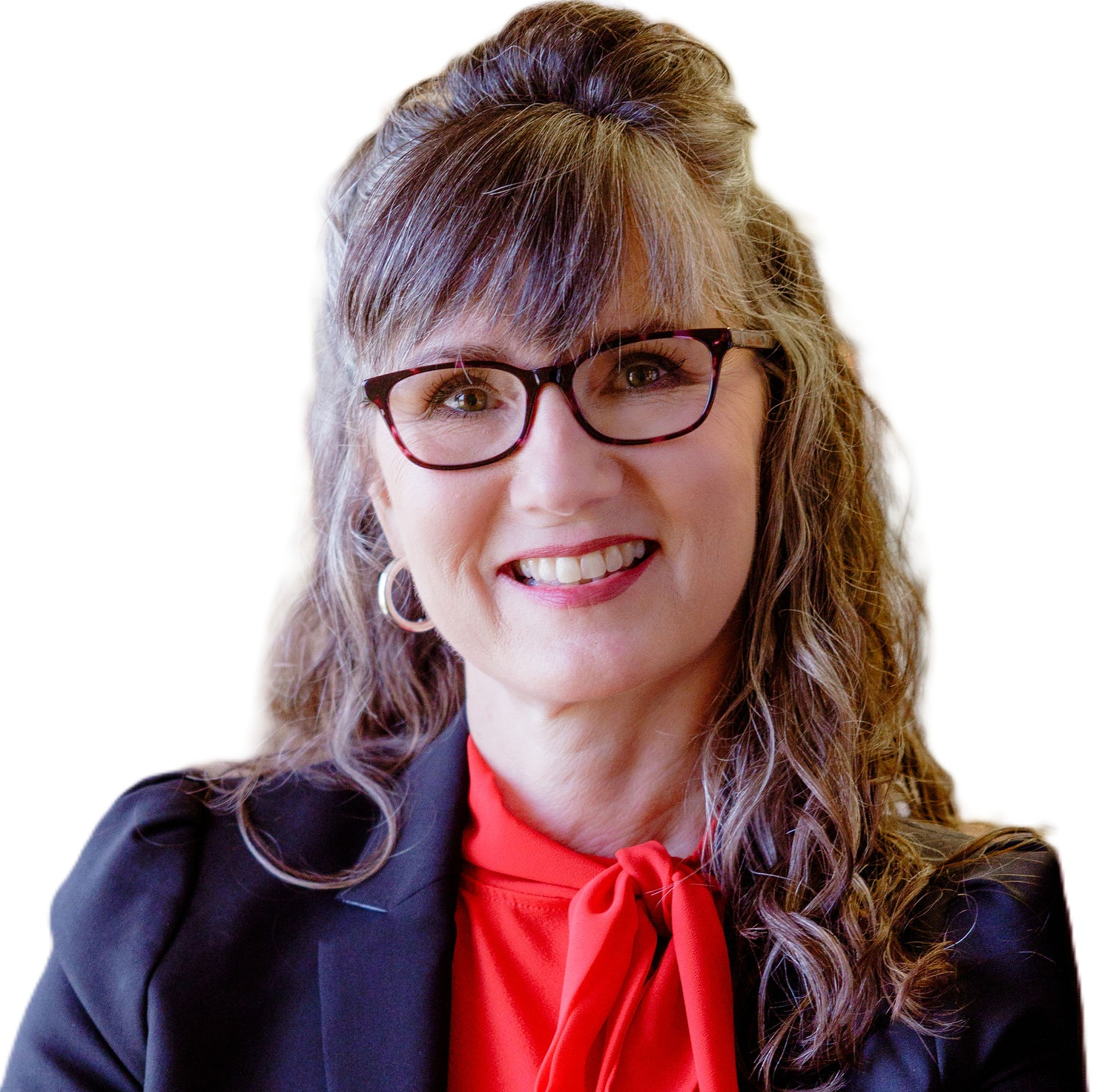A woman in a tan jacket and white shirt is standing in front of a white background.