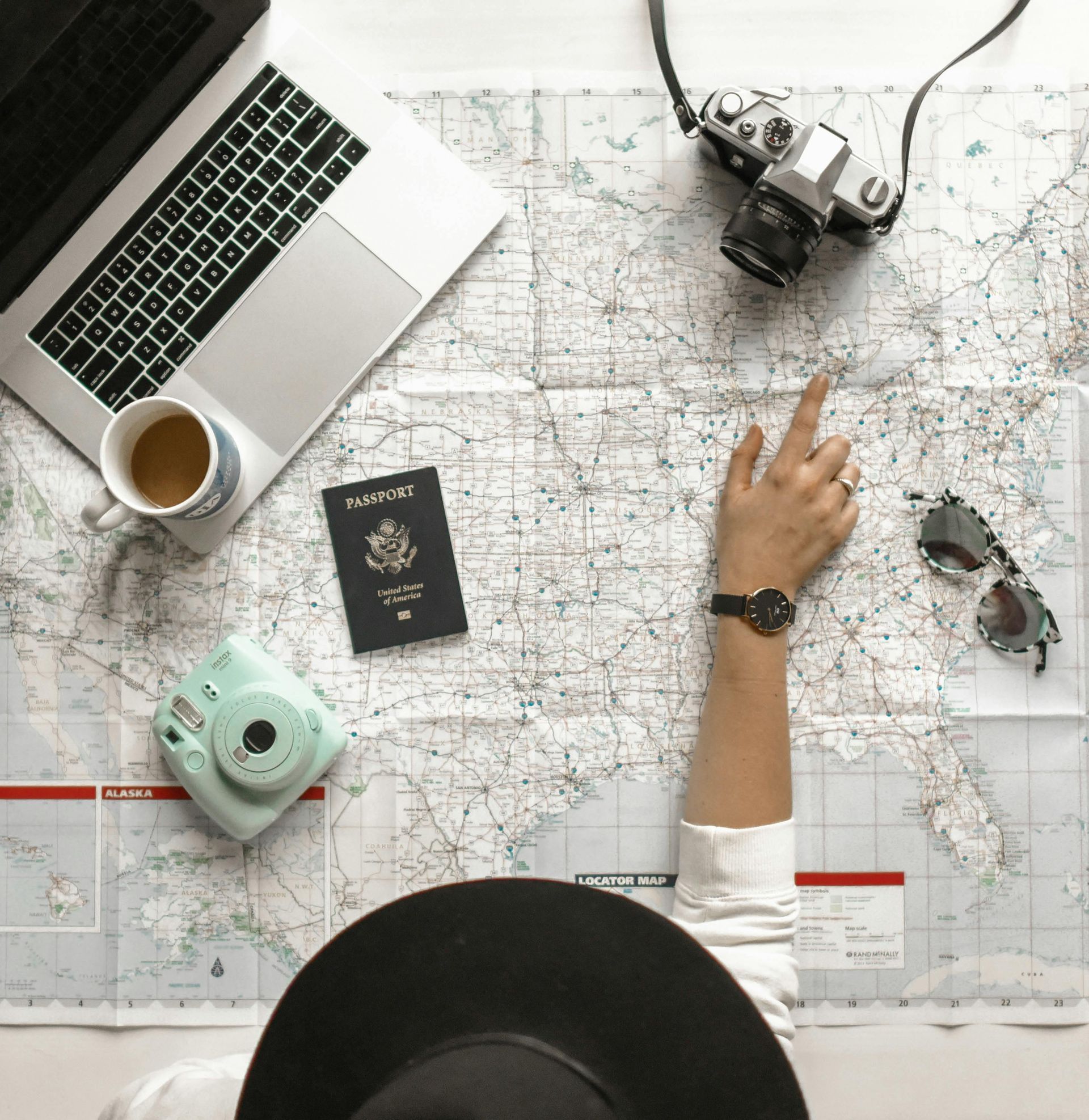 A person is pointing at a map with a passport on it