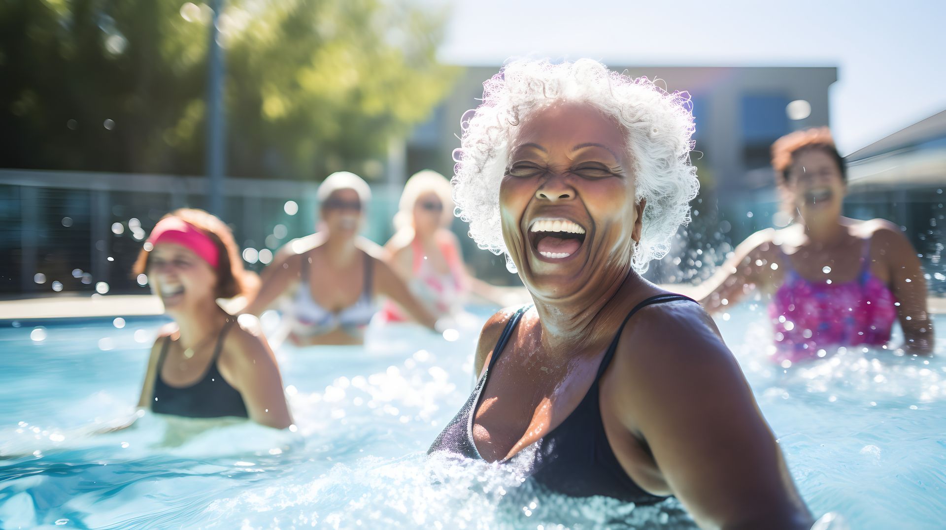 A group of older women are laughing in a swimming pool.