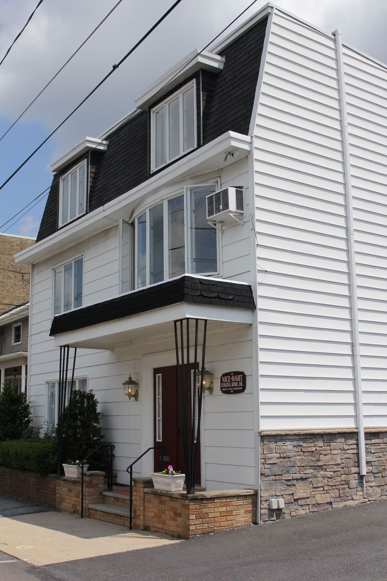 A white house with a black roof and a red door
