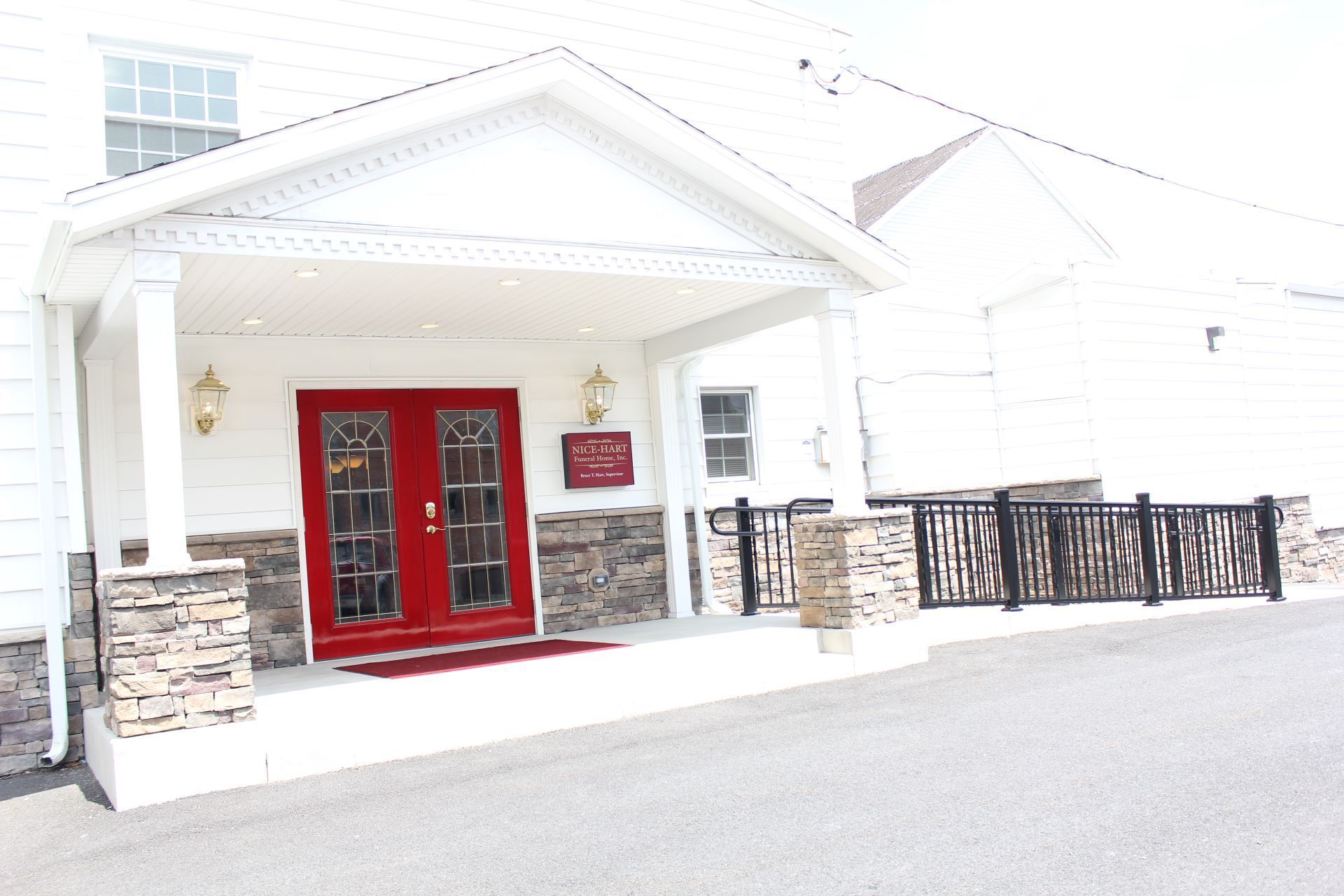 A white house with a red door and a porch