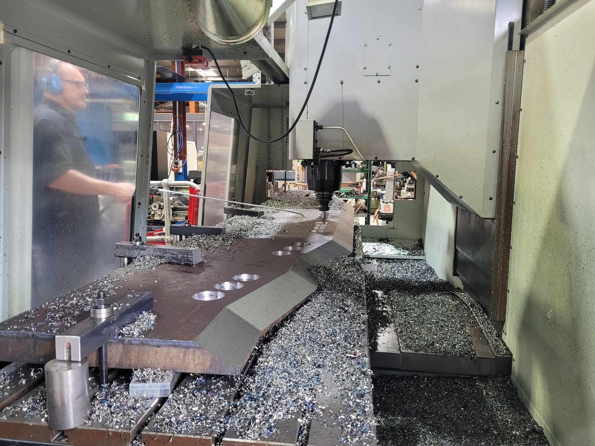 CNC machine interior cutting metal, with aluminum chips scattered around the worktable — Real Engineering In Gosford, NSW