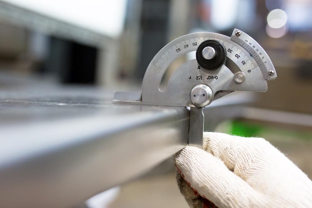 A Person Is Measuring A Piece Of Metal With A Protractor — Real Engineering In Wyong, NSW
