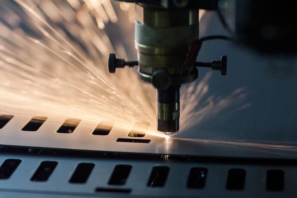 A Machine Is Cutting A Piece Of Metal With A Lot Of Sparks Coming Out Of It — Real Engineering In Newcastle, NSW