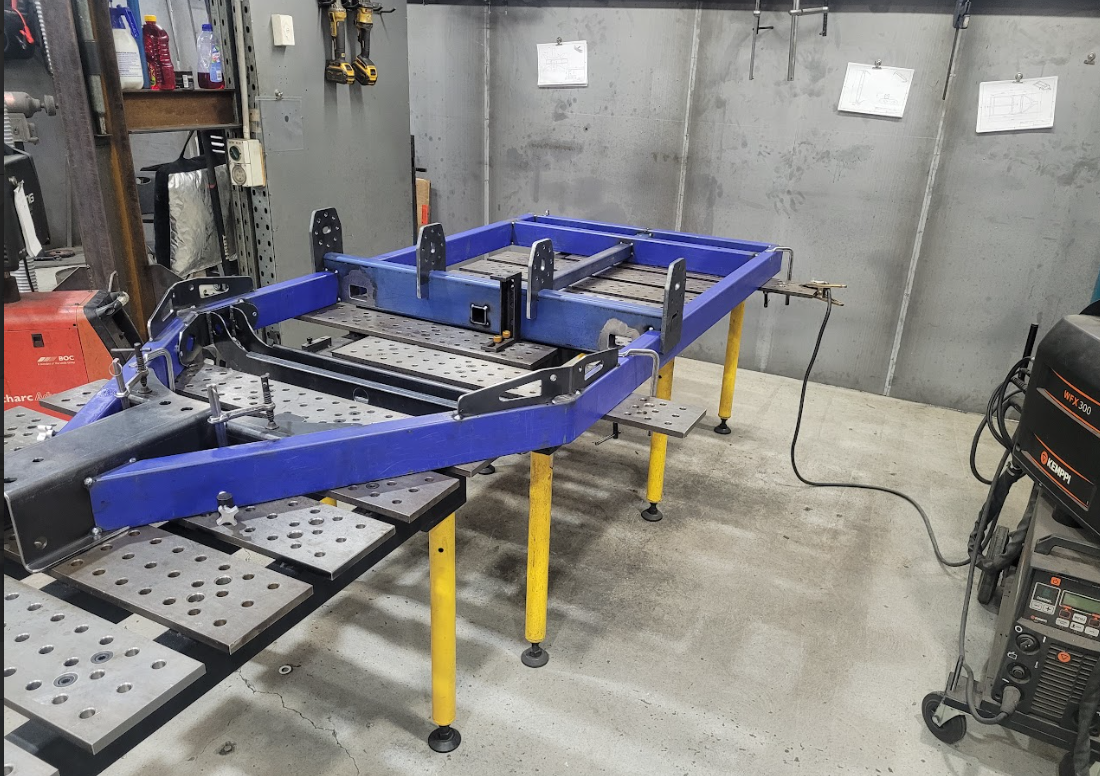 a Man is Welding a Piece of Metal on a Table in a Factory — Real Engineering In West Gosford, NSW