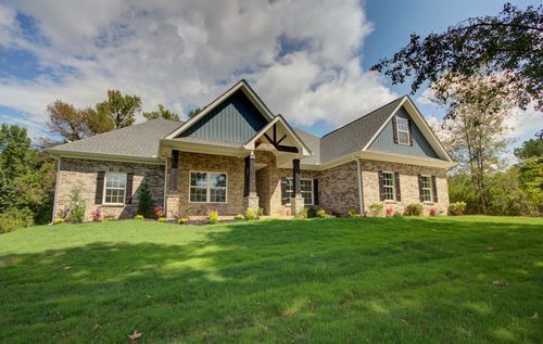 A brick house with a white garage door and a concrete driveway.
