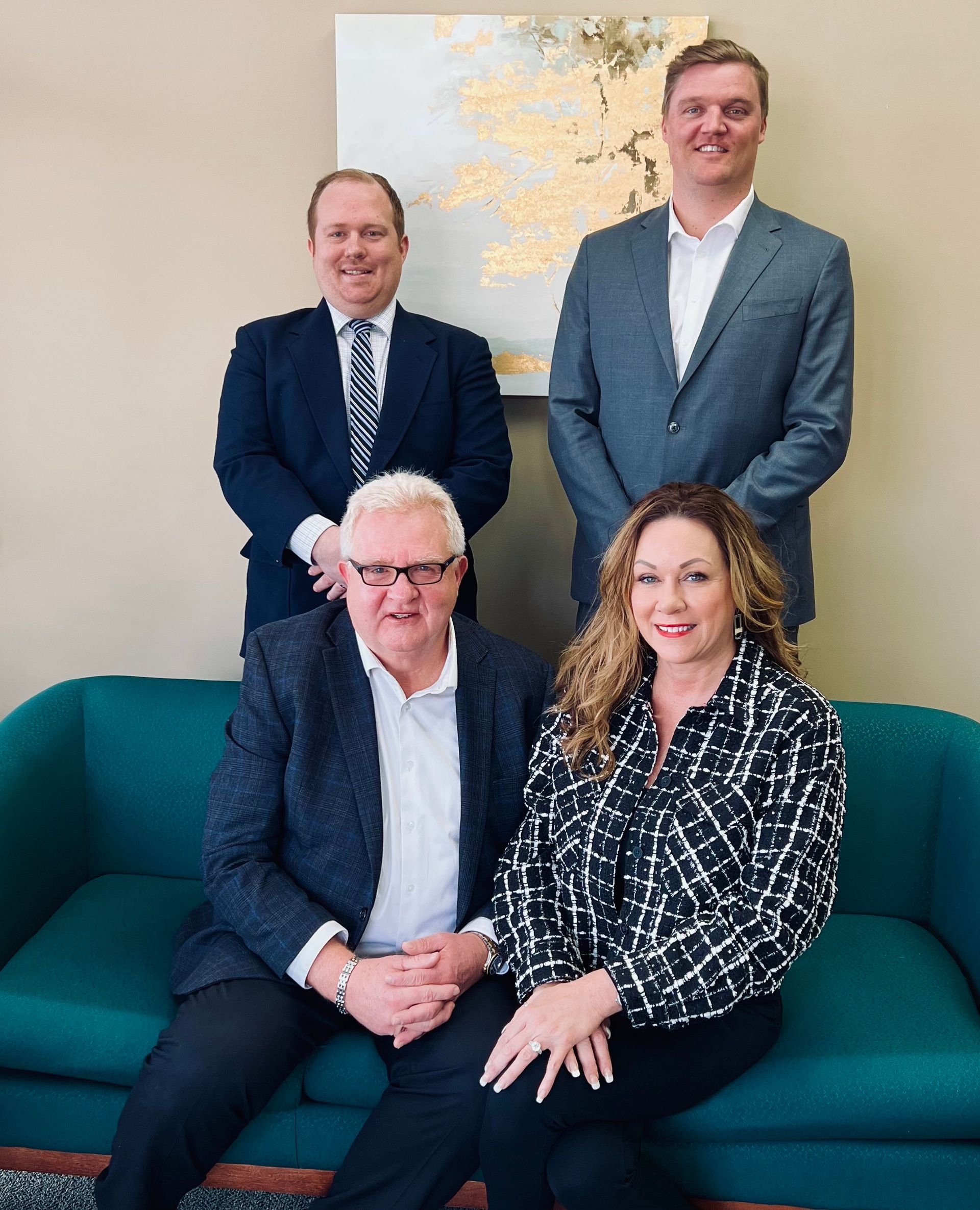 A group of people are posing for a picture while sitting on a couch.