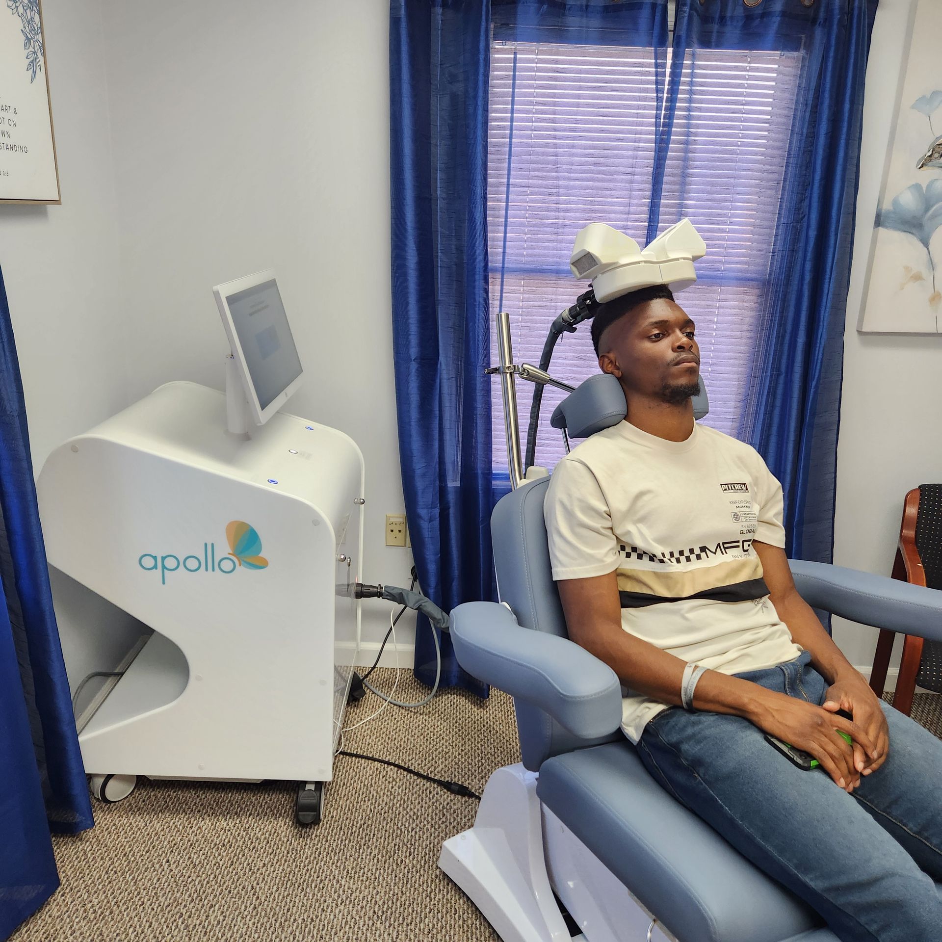 Man seated in medical chair, receiving treatment. Machine labeled