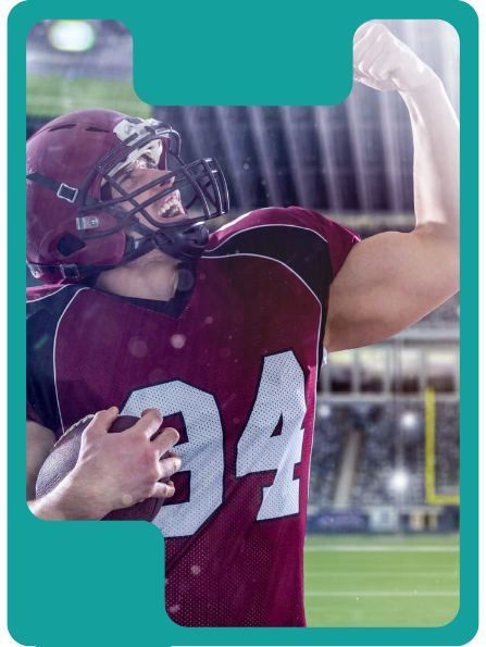 Football player in maroon jersey celebrates with arm raised, holding the ball, in a stadium.