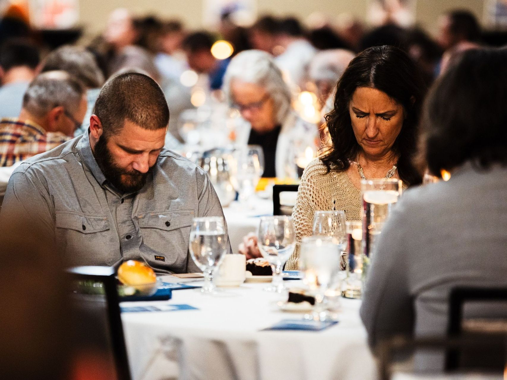 A man and a woman are sitting at a table with wine glasses.