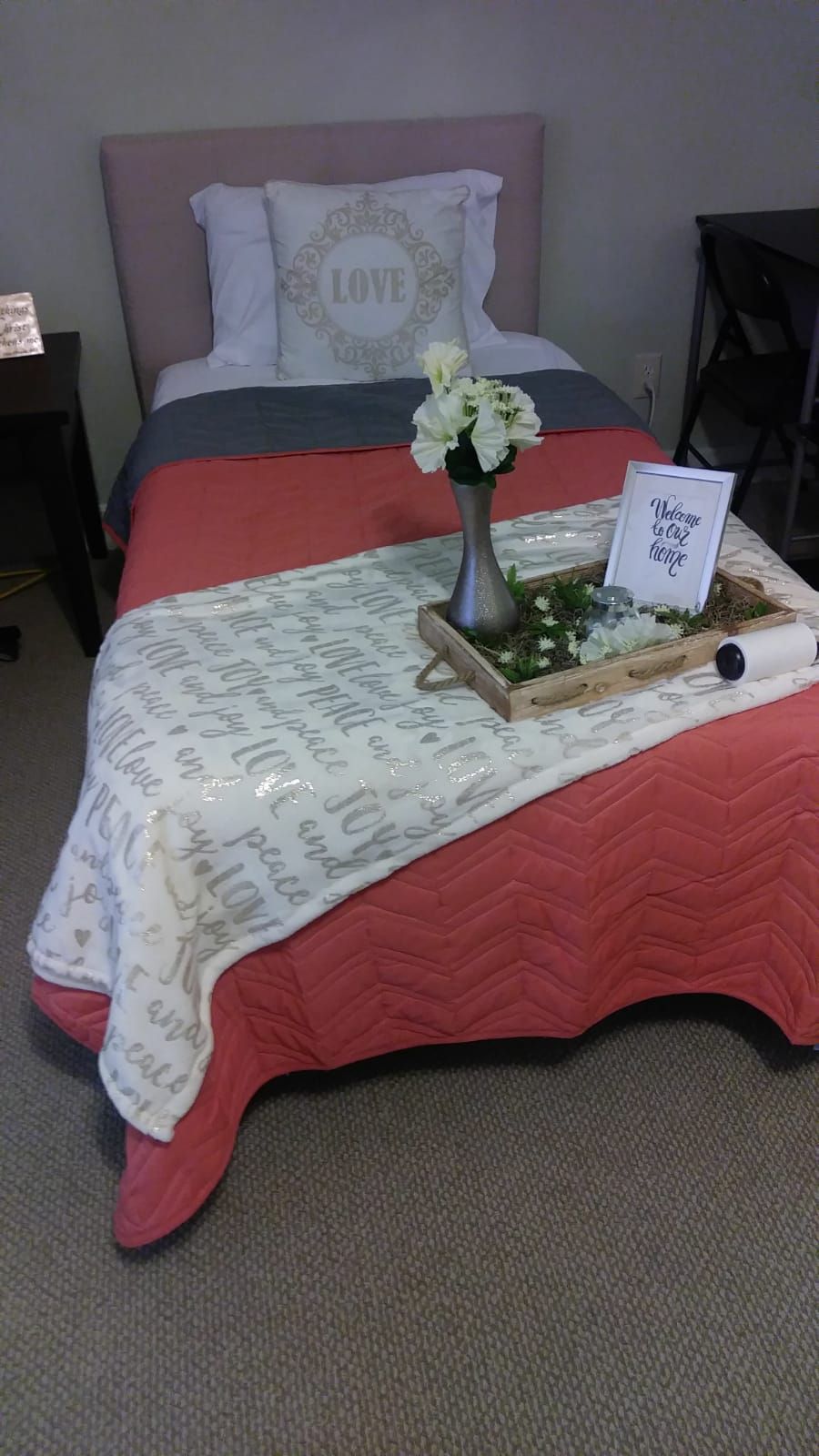Bed with coral quilt, gray blanket, white pillow with 