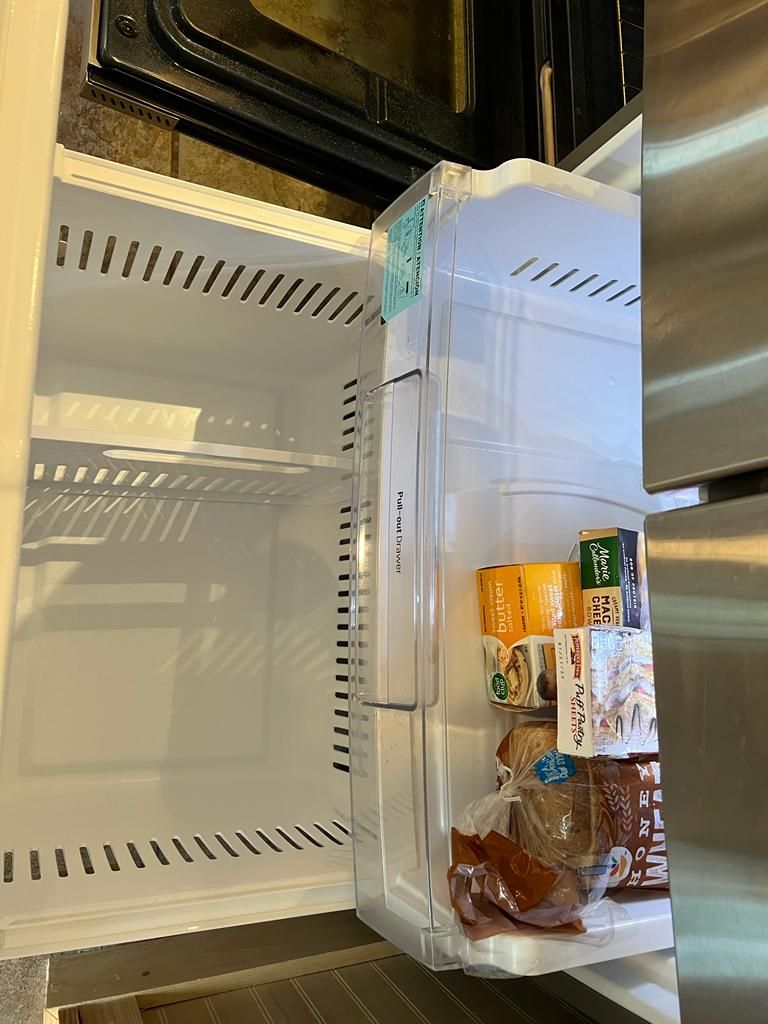 Open refrigerator with side door ajar; contains food items.