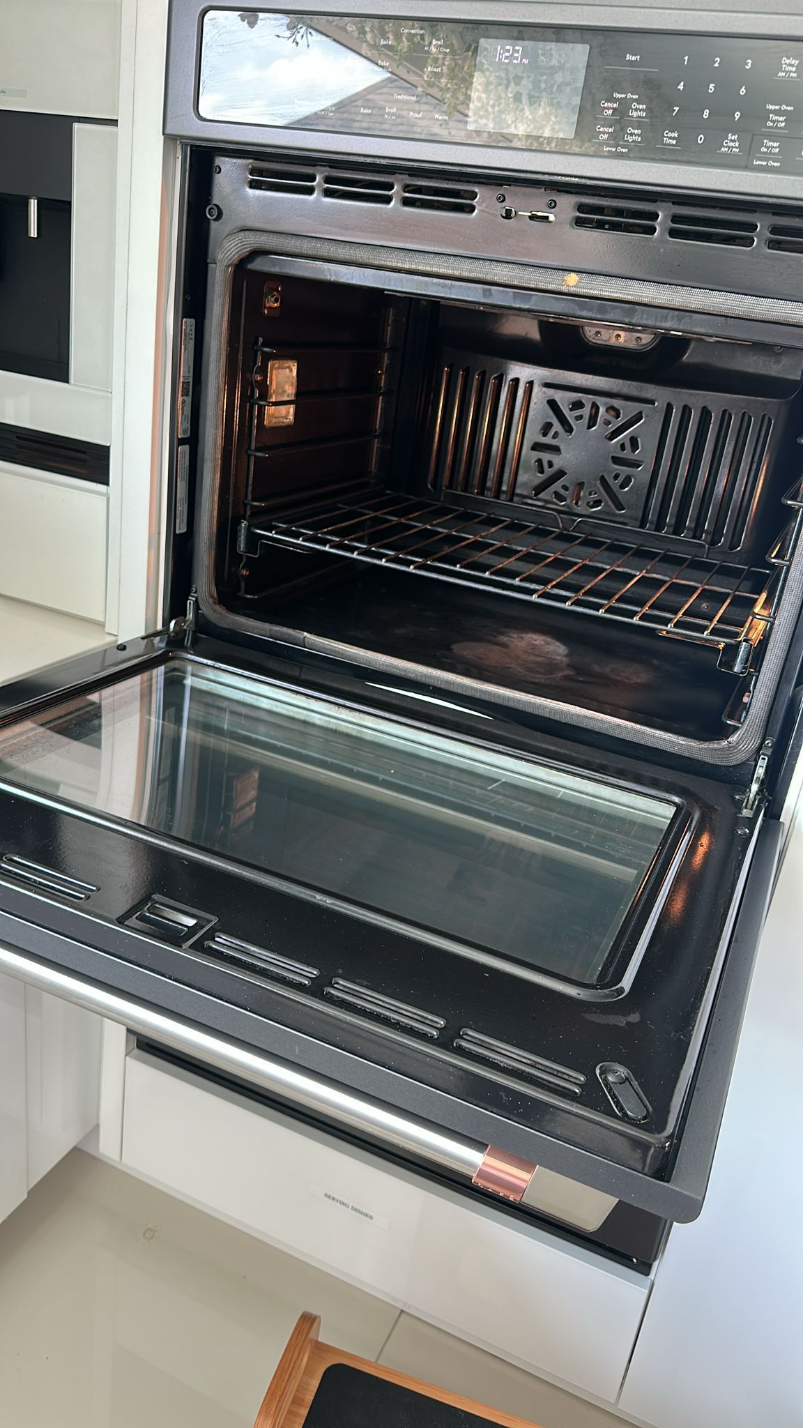 Open oven with interior racks and fan visible. Silver frame with glass door.