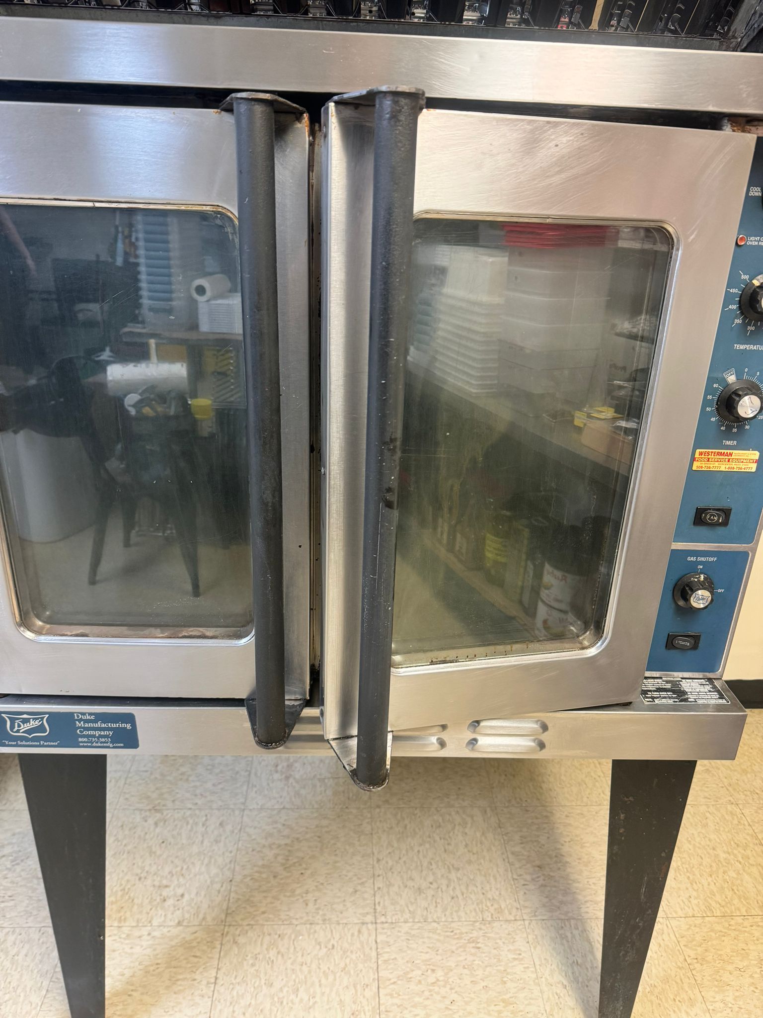 Commercial double oven with glass doors, stainless steel exterior, and black handles.