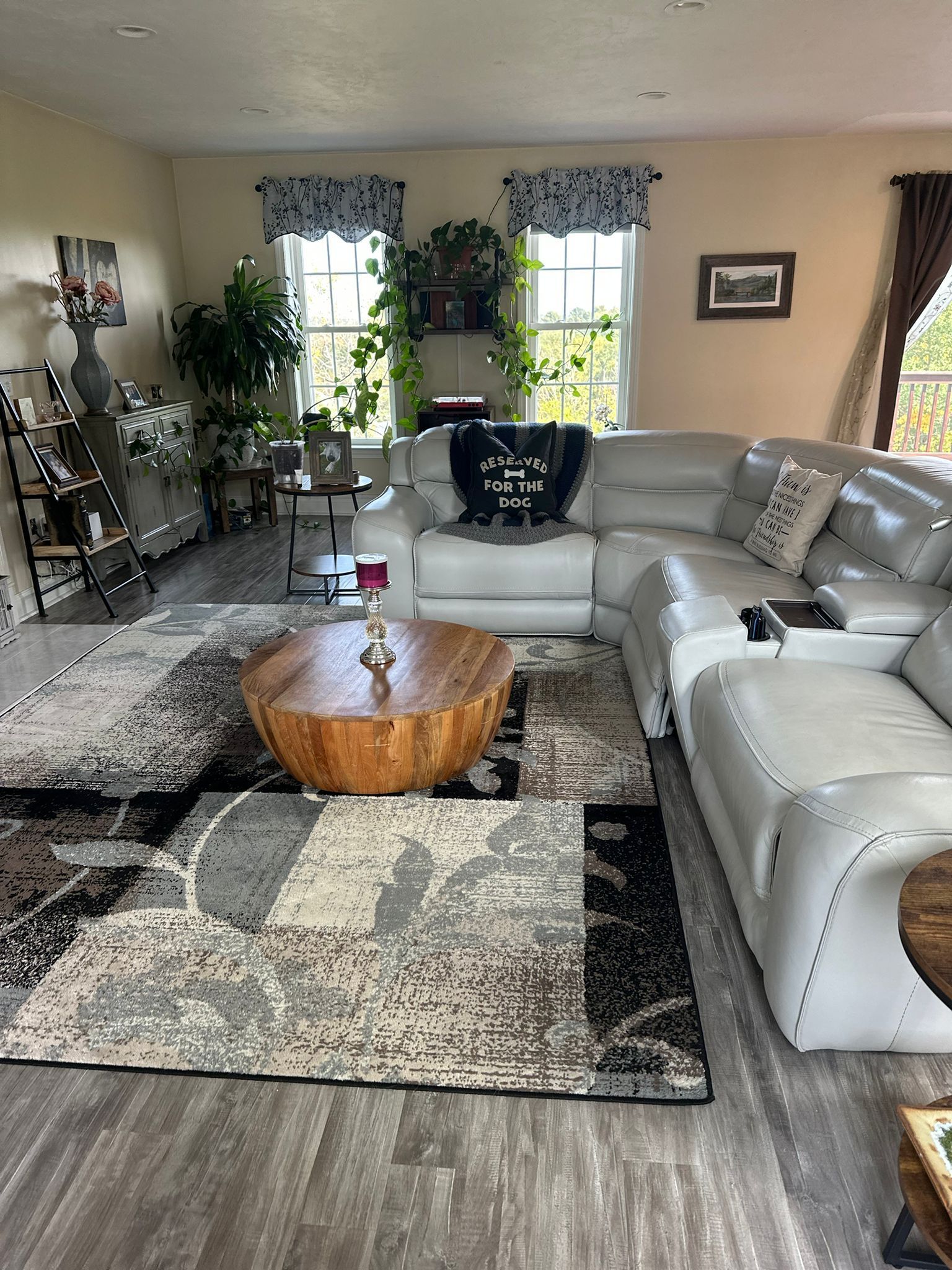 Living room with a large gray sectional sofa, patterned rug, and wooden coffee table.