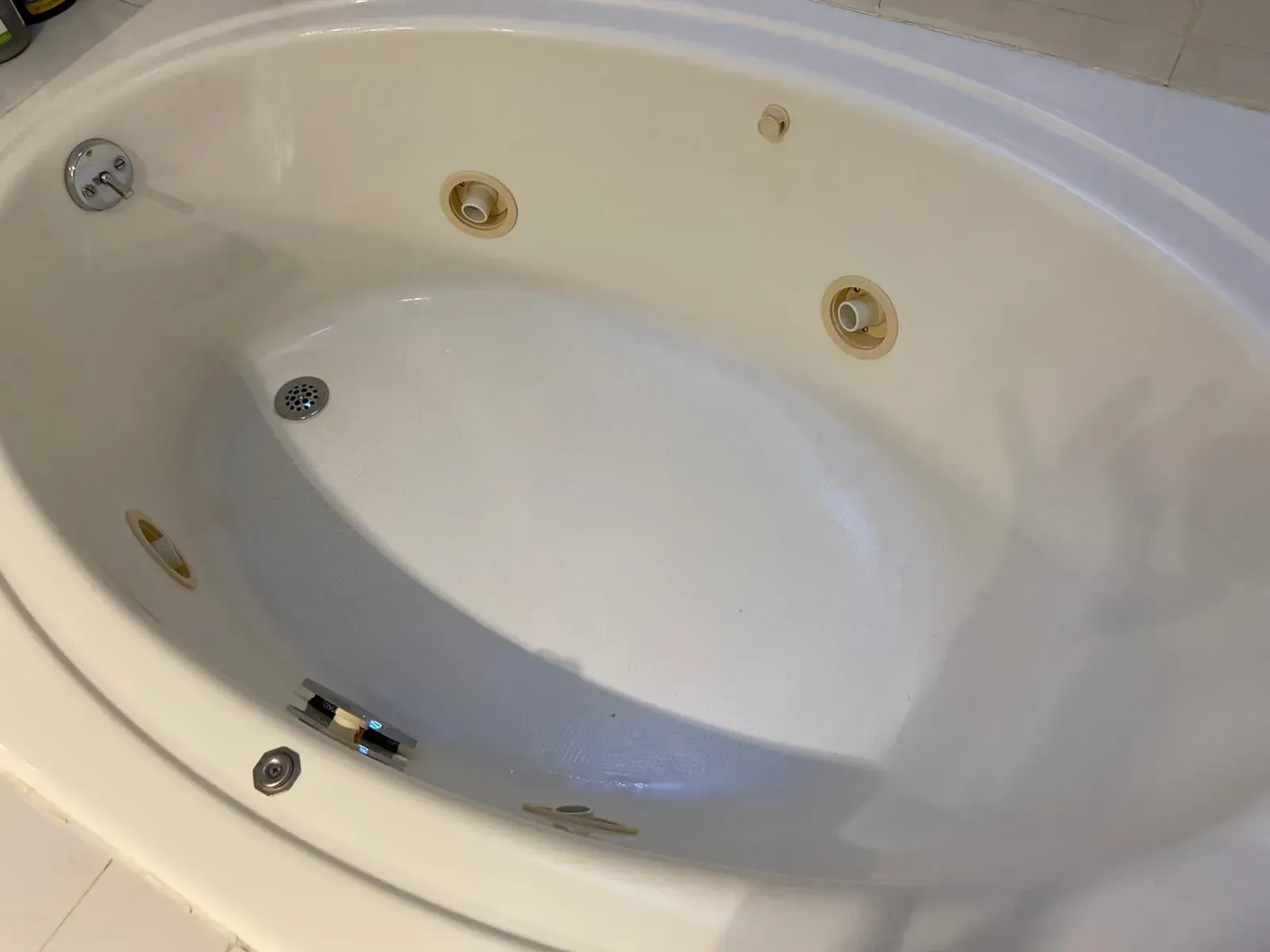 White oval whirlpool tub with multiple jets.