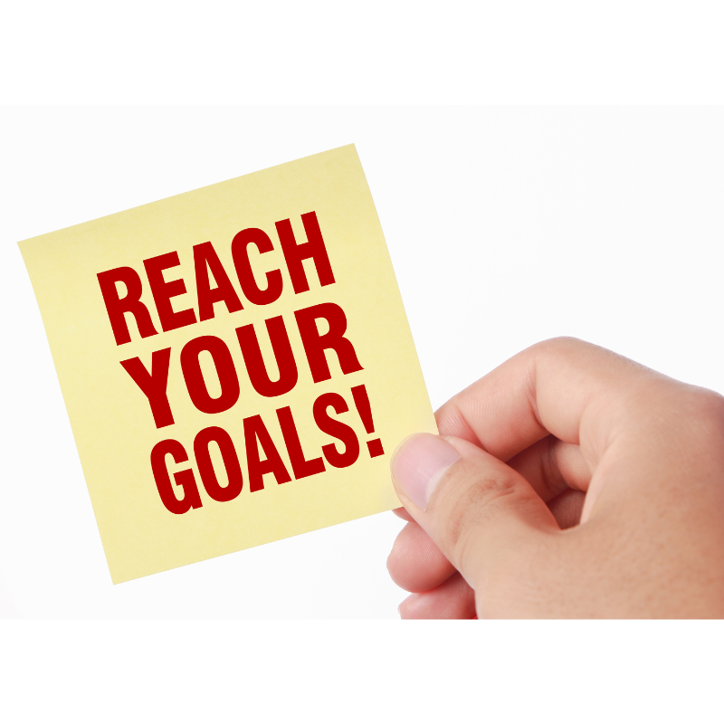 a hand is holding a sticky note that says reach your goals