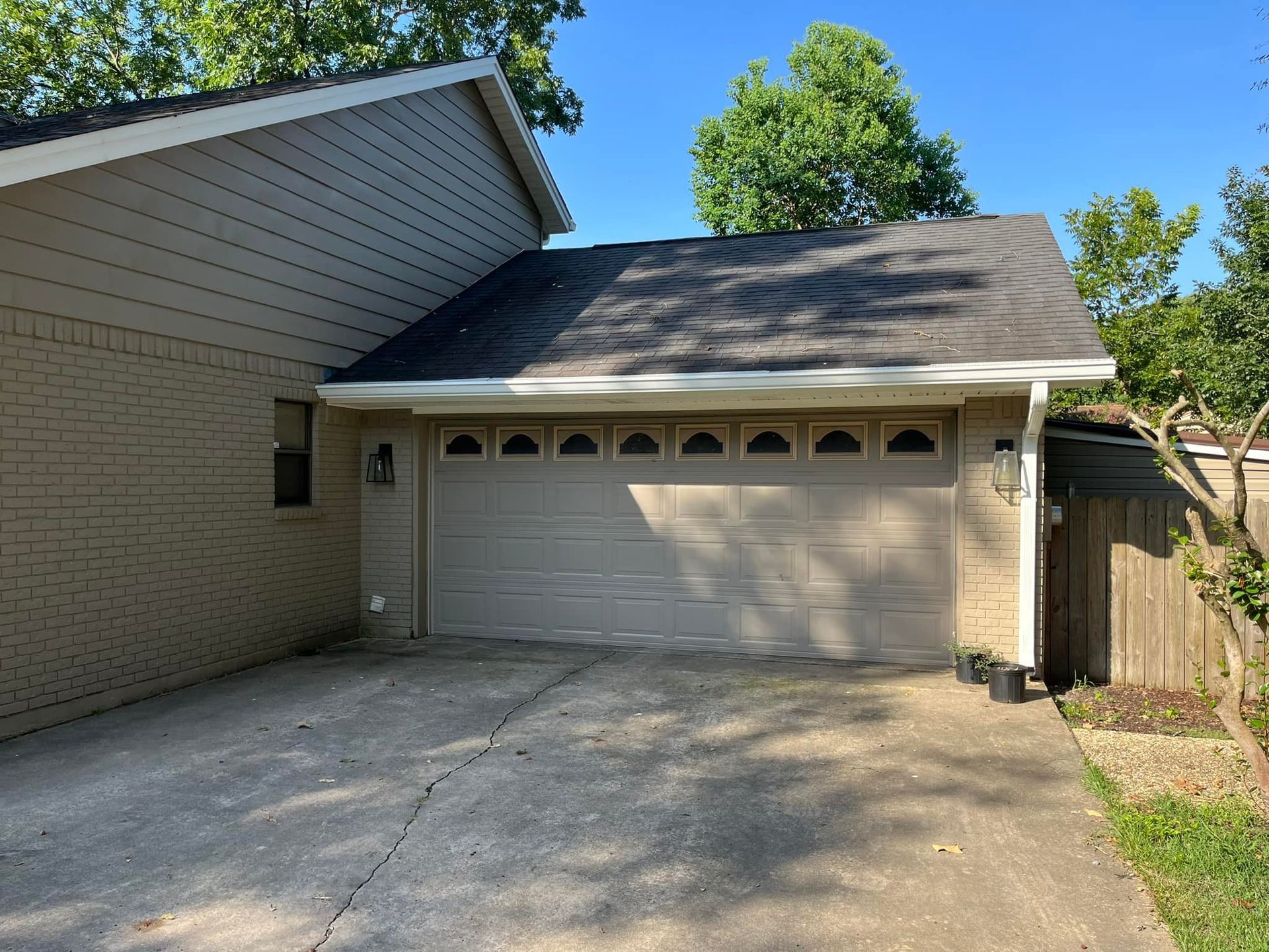 A house with a garage and a driveway in front of it.