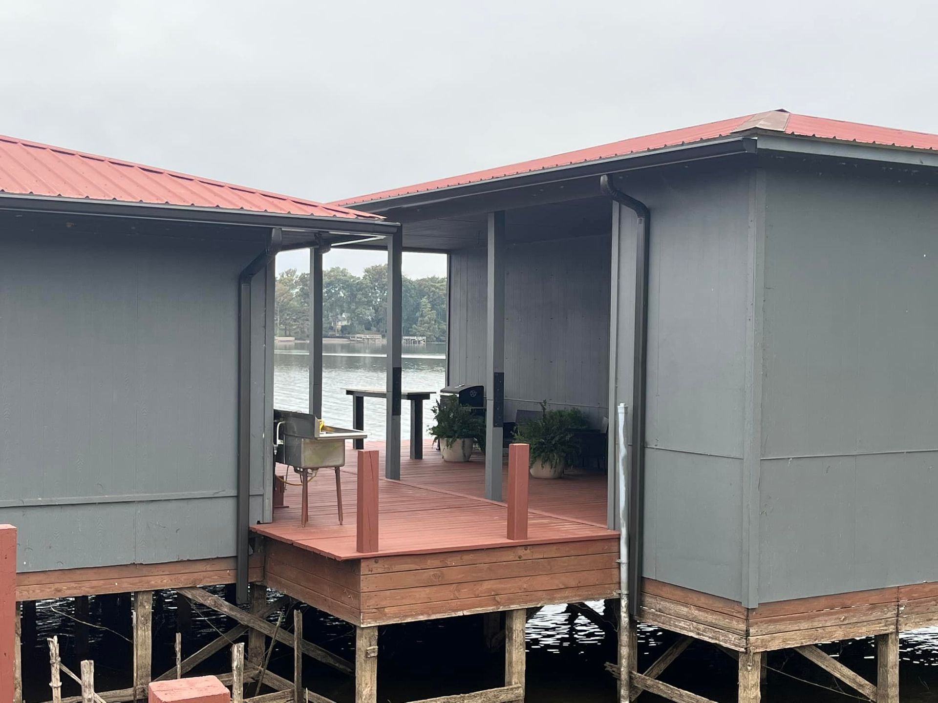 A couple of houses on stilts next to a body of water.