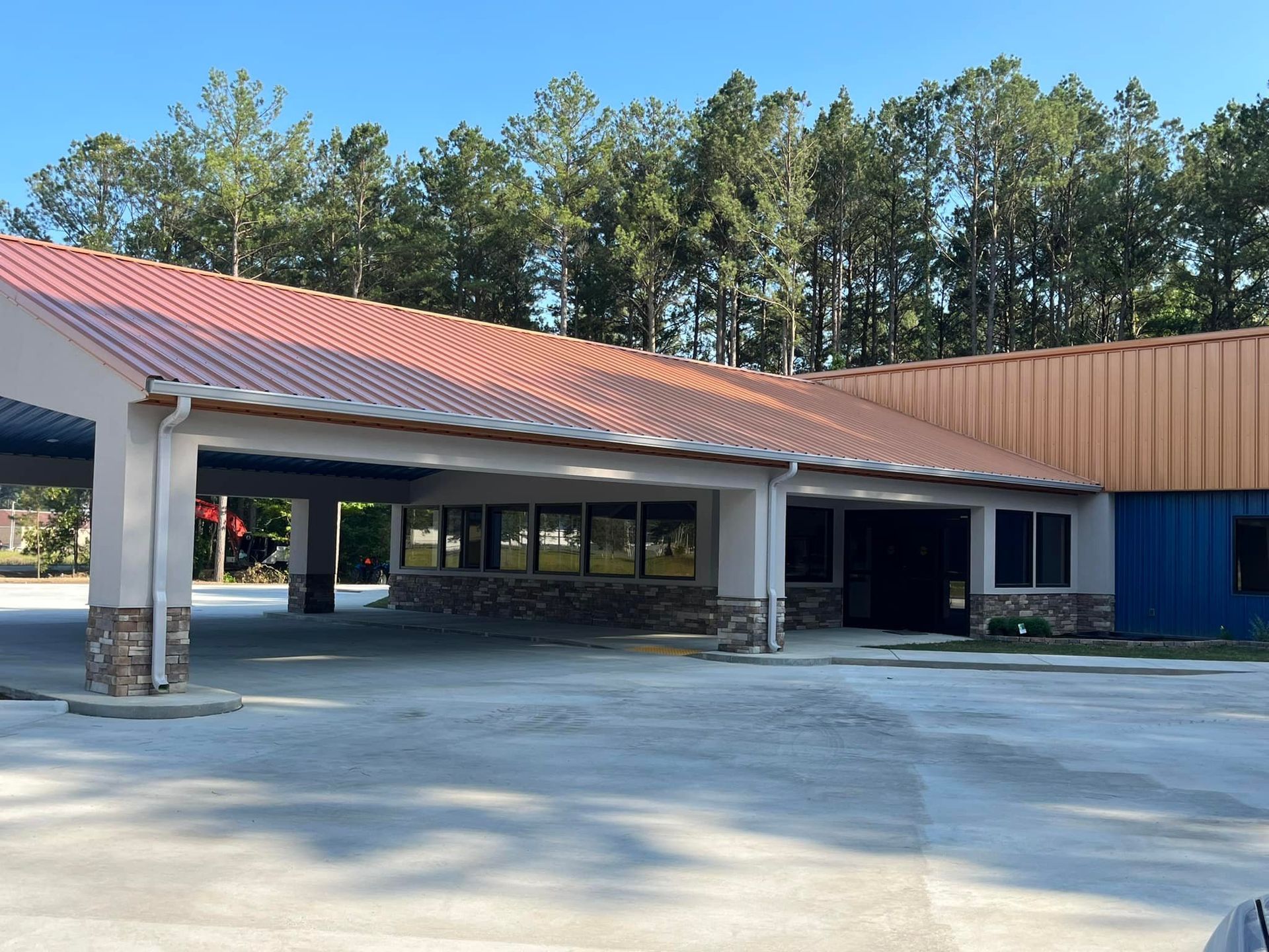 A large building with a red roof and trees in the background