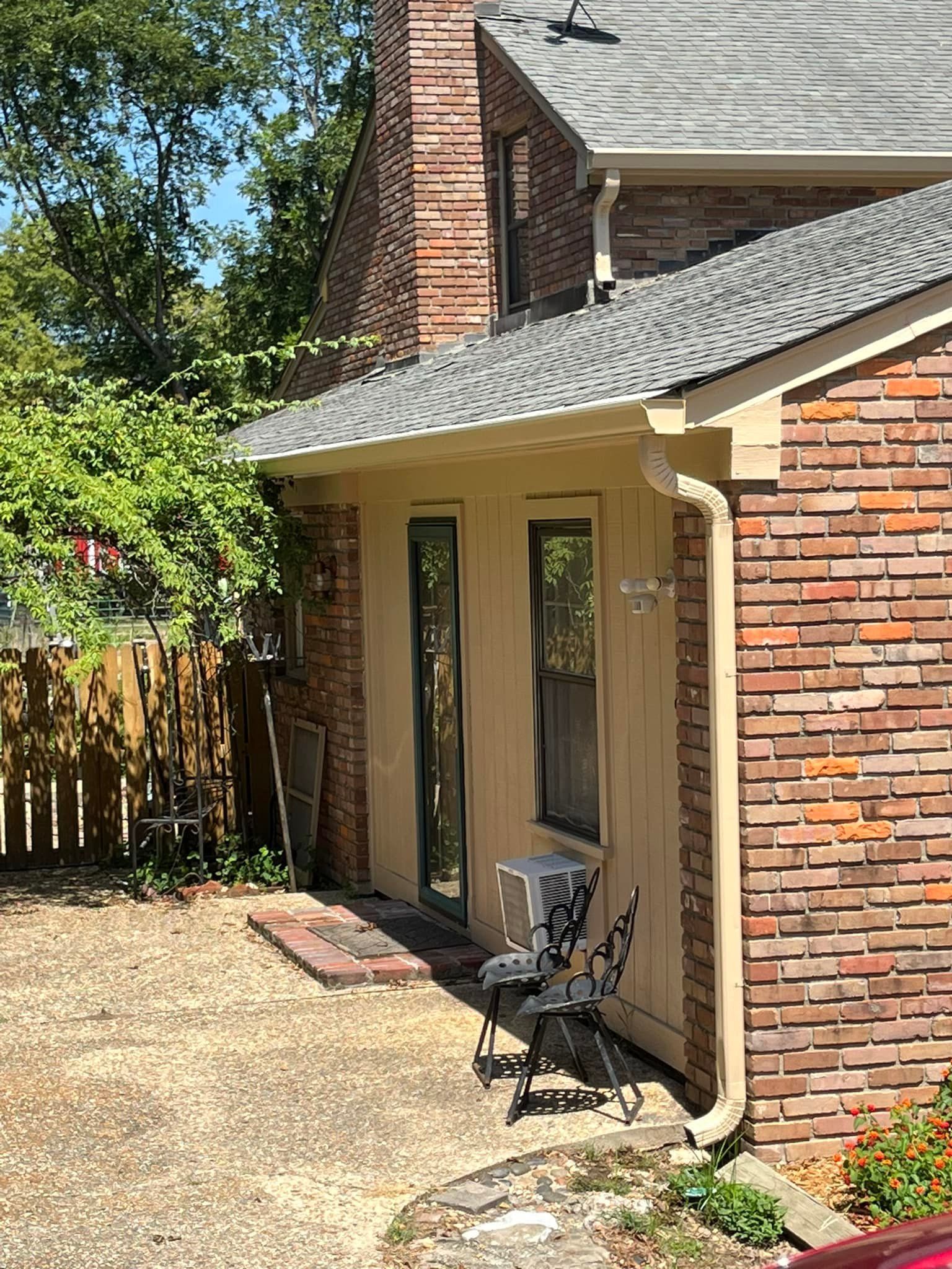 A brick house with a car parked in front of it.