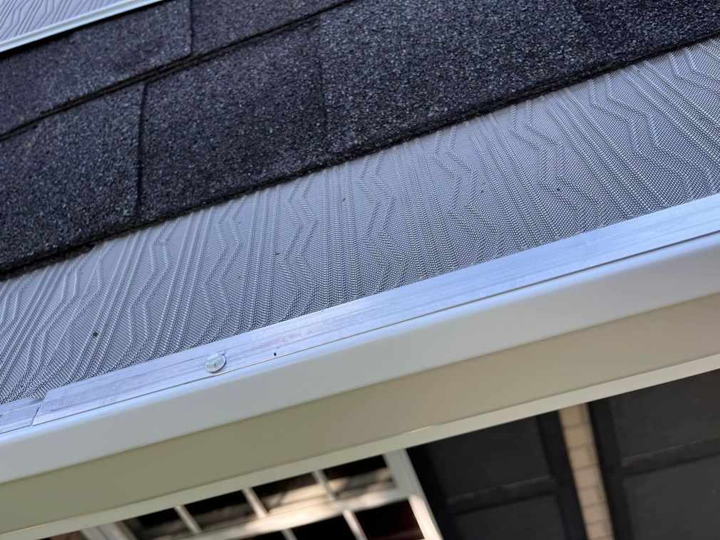 A close up of a gutter on the side of a house.