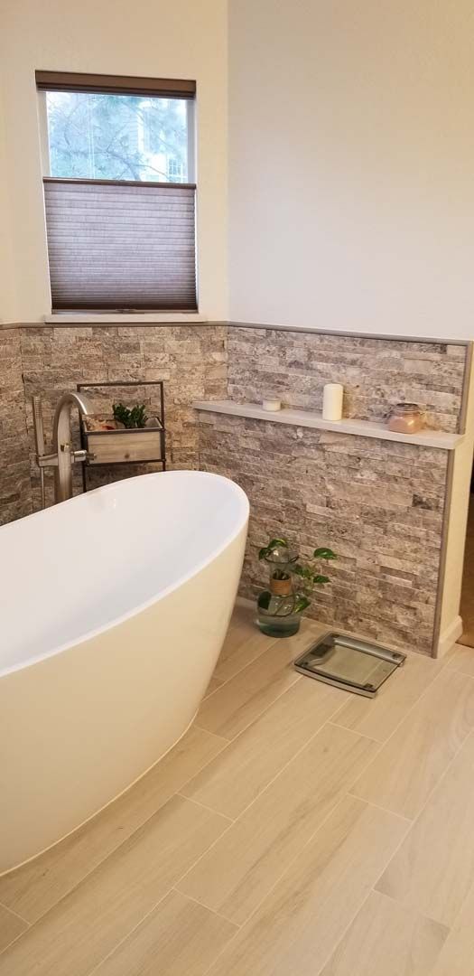 A bathroom with a bathtub and a scale on the floor.