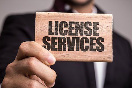 Man Holding A Piece Of Wood With License Services Word — Los Angeles, CA — Spiga and Associates