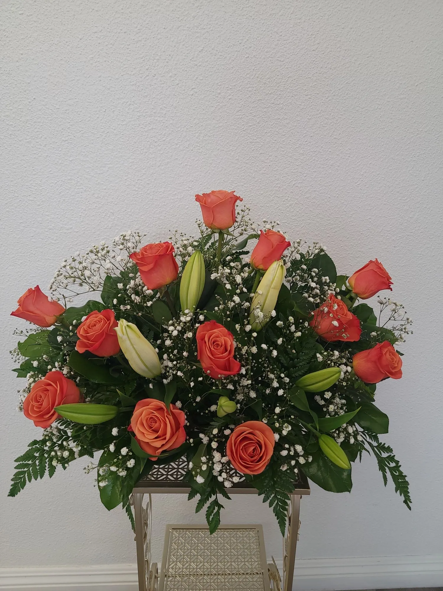 Vase filled with orange roses and white lilies