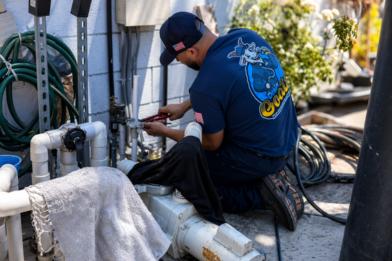 Blue and red PEX pipes snaking through unfinished wooden rafters of a building under construction.