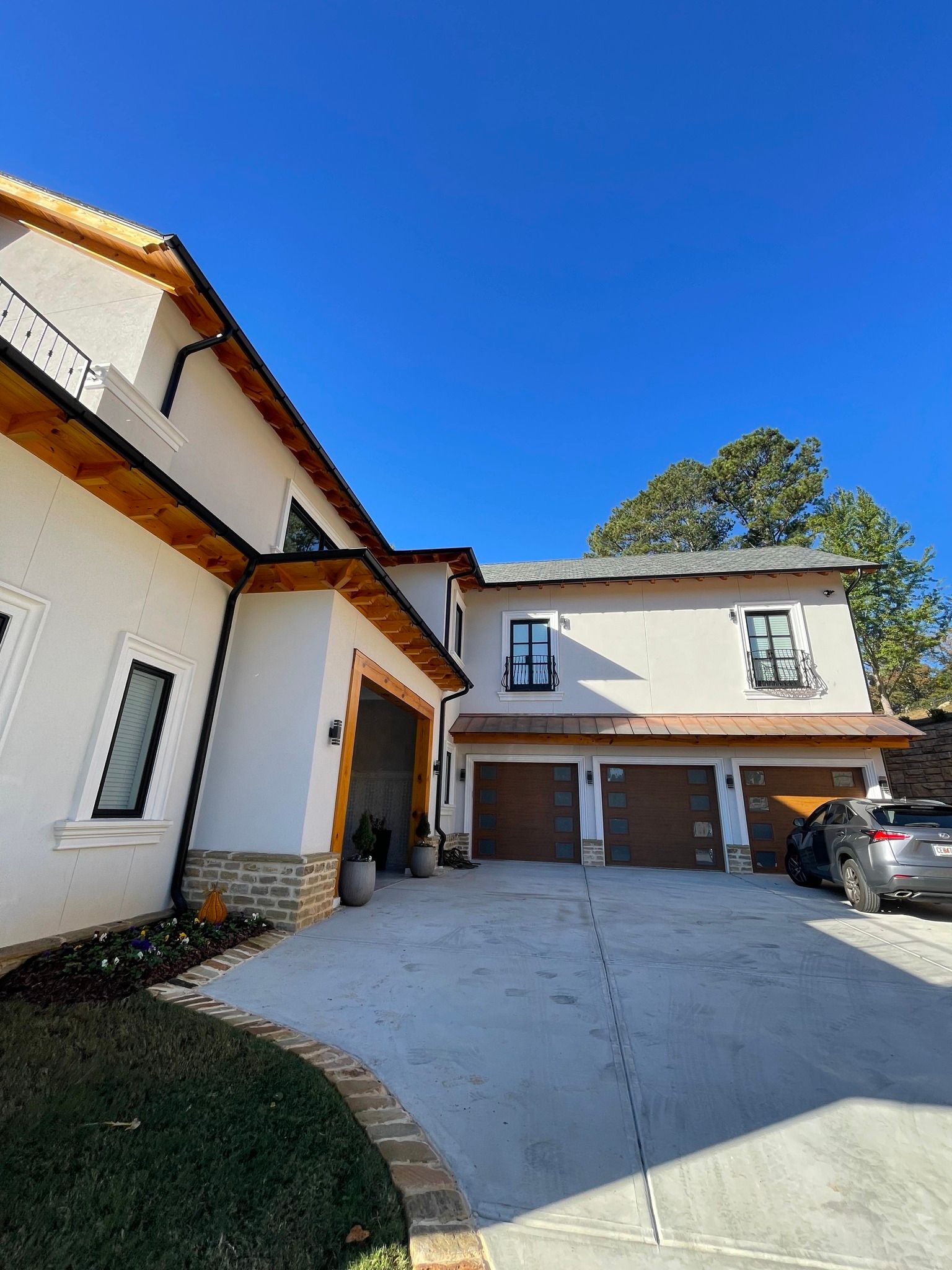 A large white house with a car parked in front of it.
