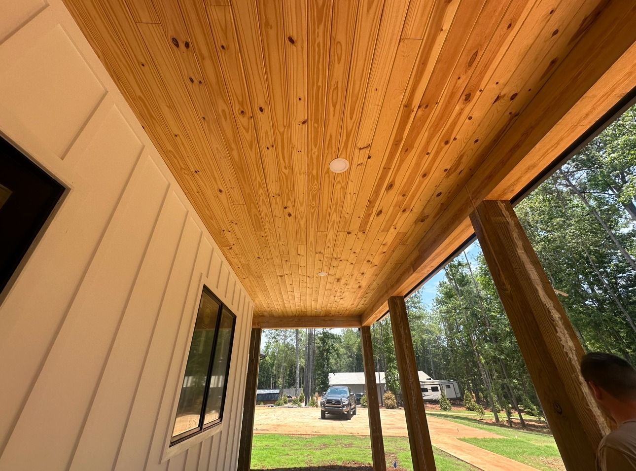A porch with a wooden ceiling and a lot of windows