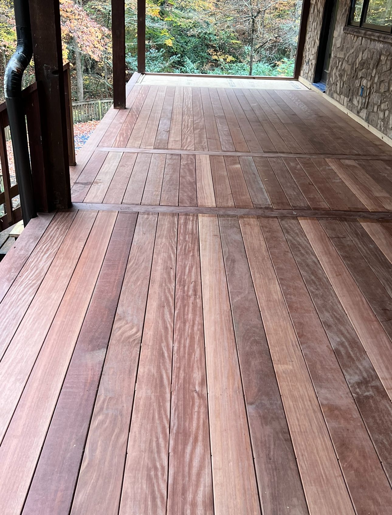 A wooden deck with a drainpipe on the side of it