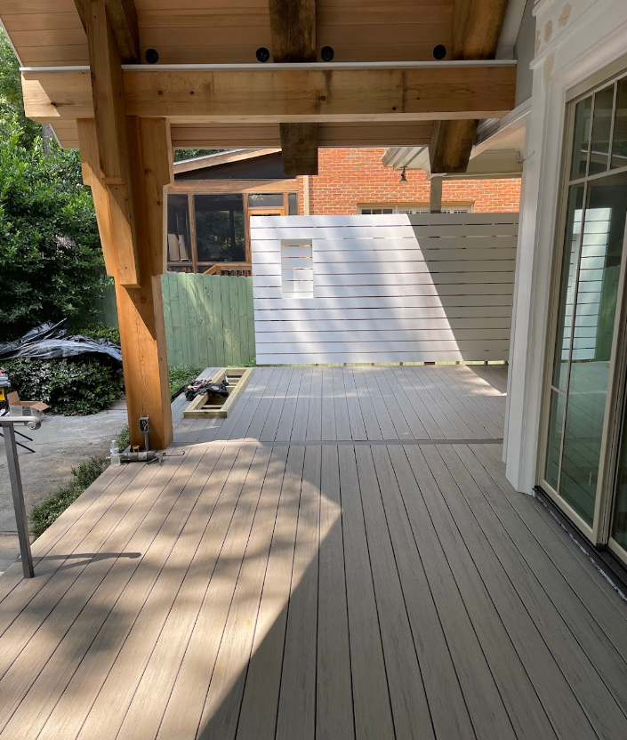 A wooden deck with a white fence in the background