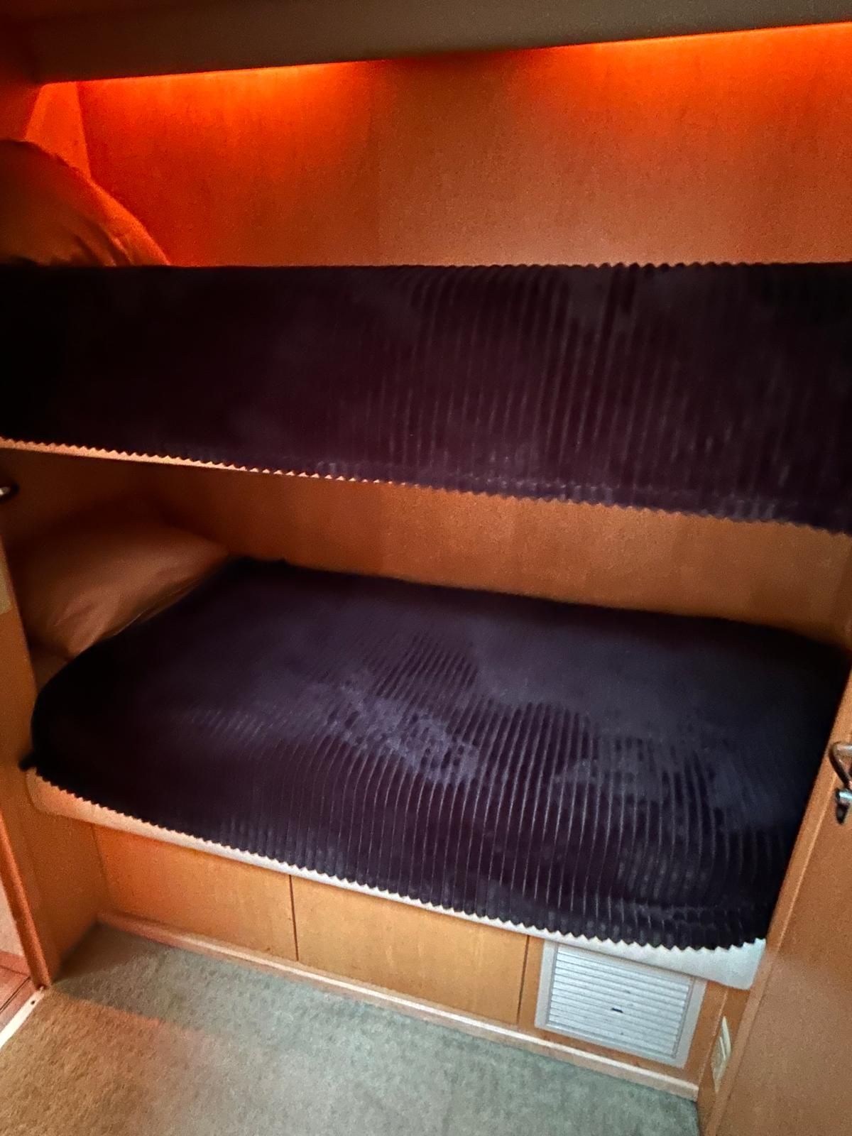 A bunk bed with a blue blanket on it in a room.