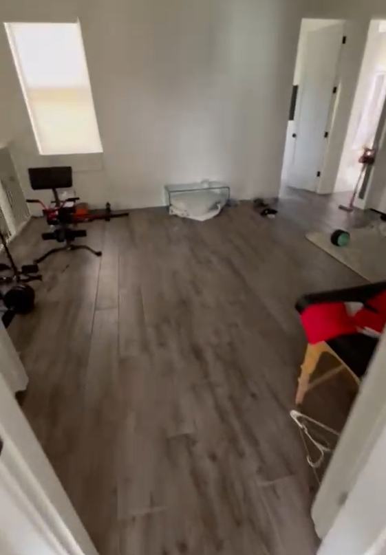 An empty room with a wooden floor and white walls.
