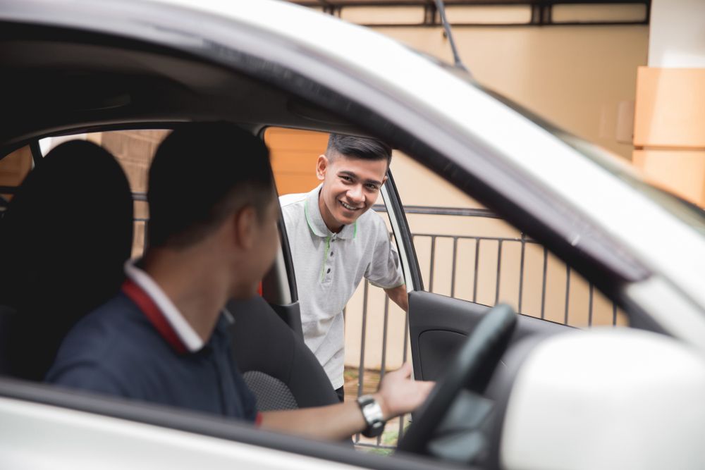 A Man is Talking to Another Man in a Car — Step Up Automotive in Southport, QLD