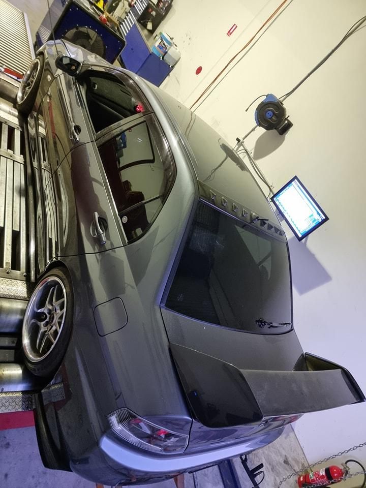 A Car is Sitting on a Lift in a Garage — Step Up Automotive in Southport, QLD