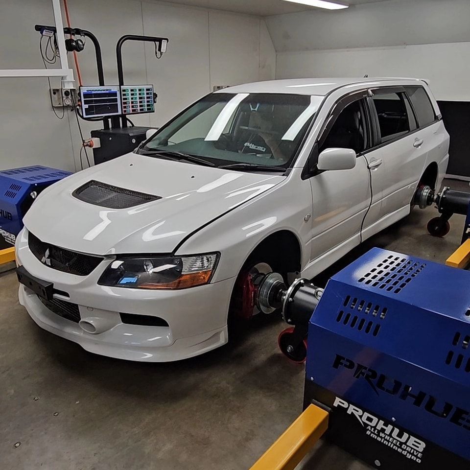 A White Car is Parked Next to a Prohub Machine — Step Up Automotive in Southport, QLD