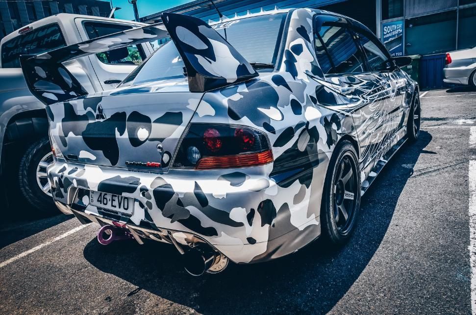 A Car With a Camouflage Paint Job is Parked in a Parking Lot — Step Up Automotive in Southport, QLD