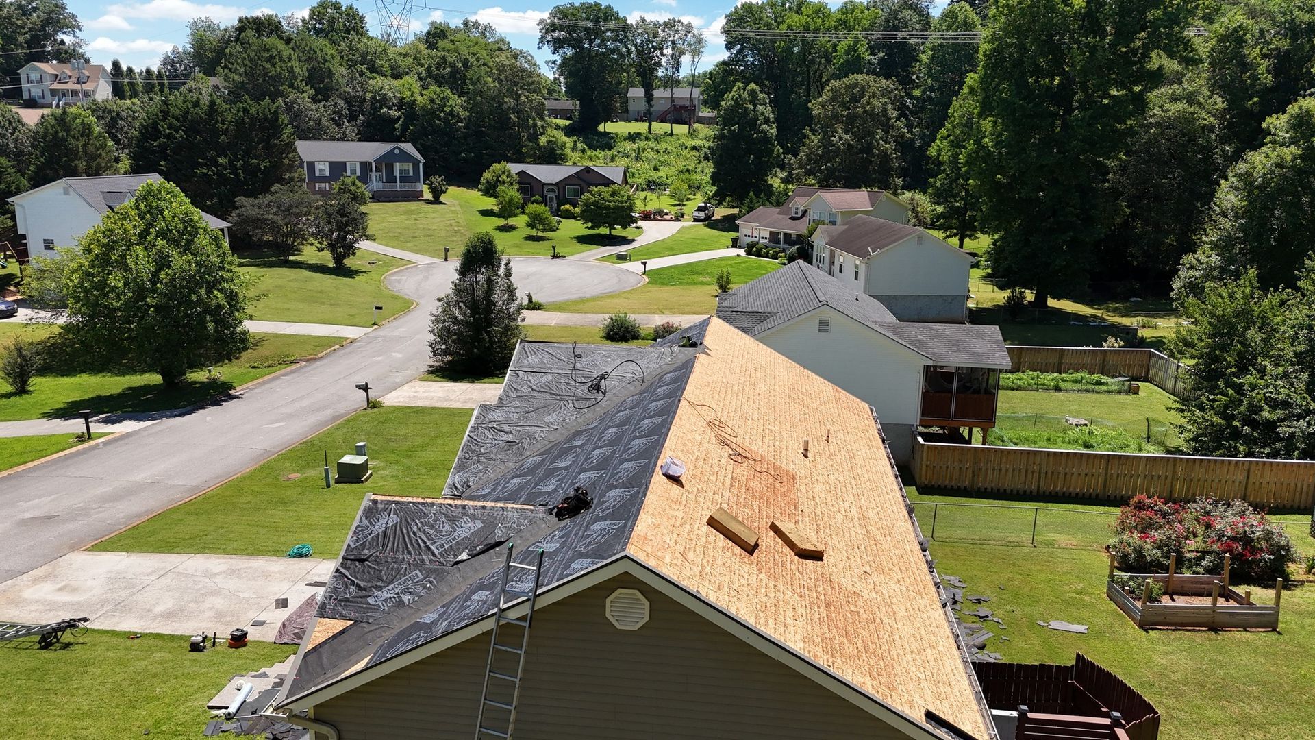 An aerial view of a house with a roof that is being repaired.