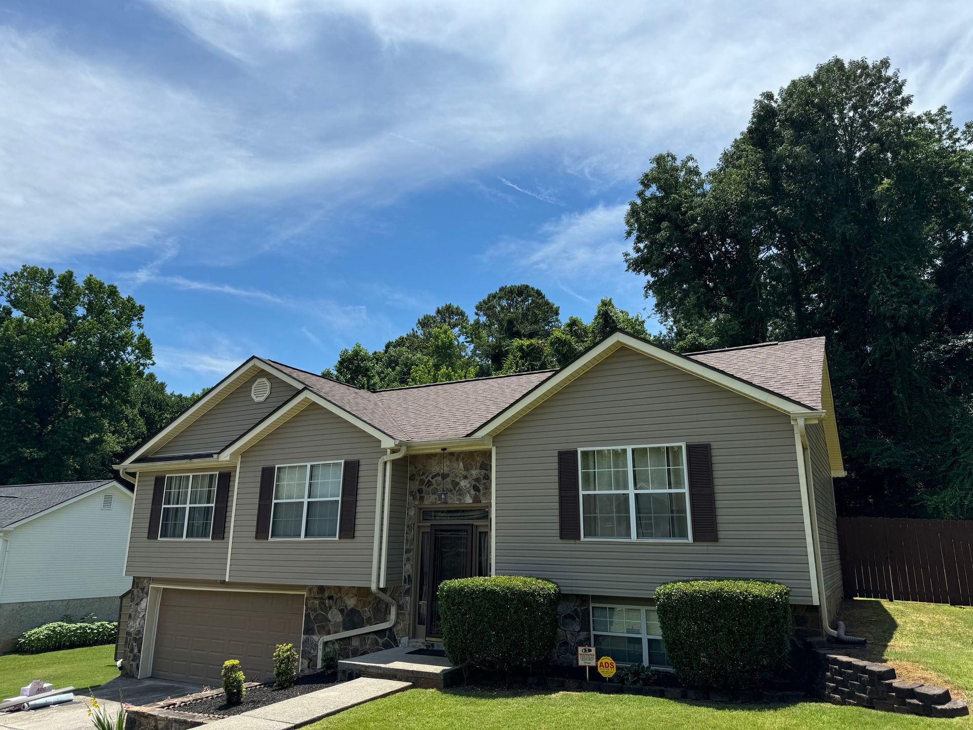 A large house with a lot of windows and trees in the background