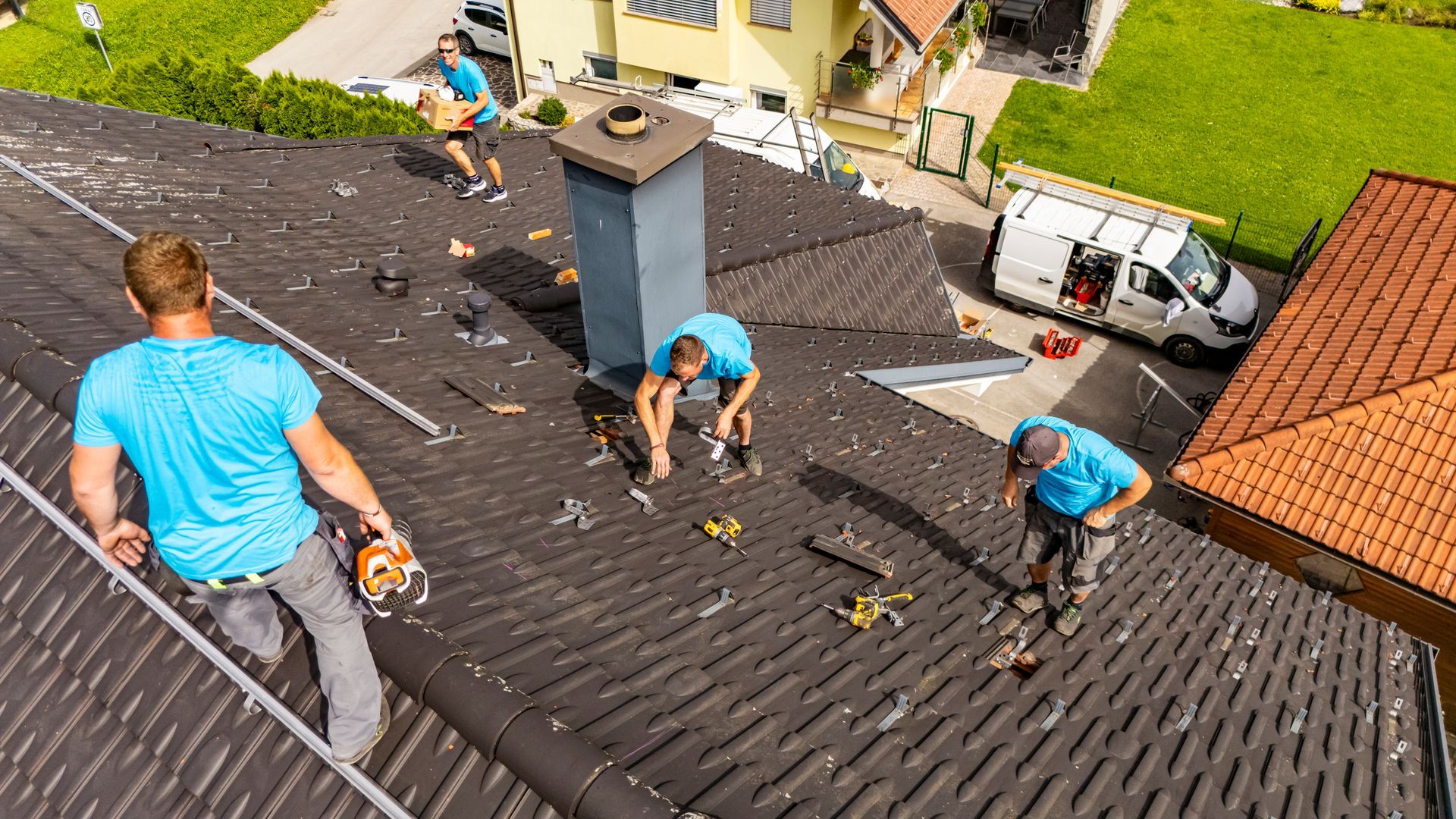 A group of men are working on the roof of a house.