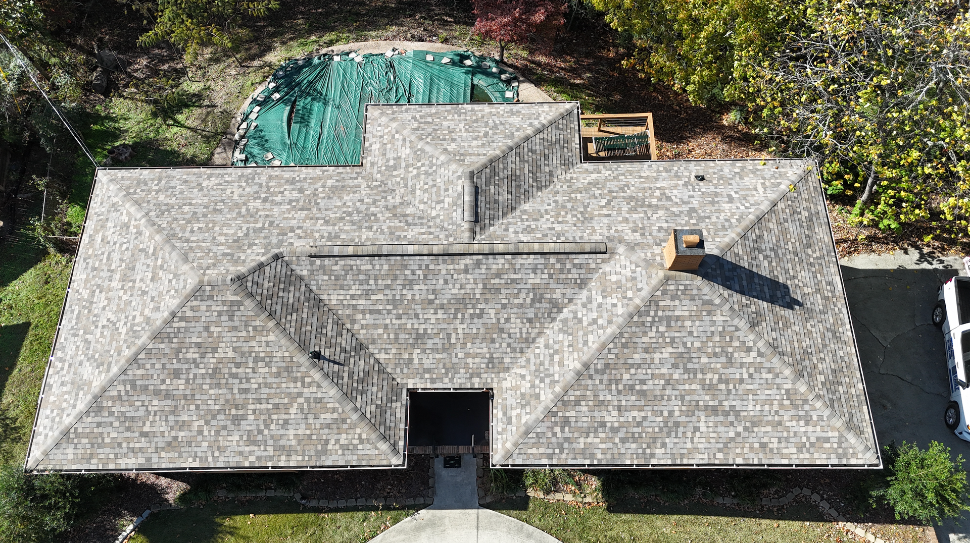 An aerial view of a house with a swimming pool in the backyard.
